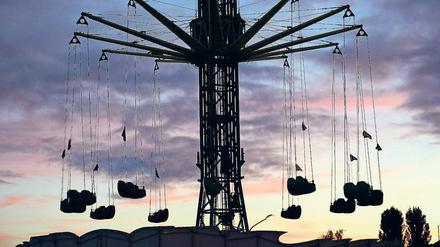 Attraktion im Dämmerlicht. „Sky Dance“ heißt der neue Nervenkitzel auf dem Oktobervolksfest im Lustgarten. Der Kettenflieger kann die Insassen bis auf eine Höhe von 55 Metern bringen. Foto: Martin Müller