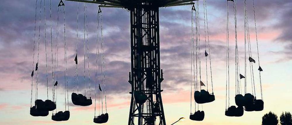 Attraktion im Dämmerlicht. „Sky Dance“ heißt der neue Nervenkitzel auf dem Oktobervolksfest im Lustgarten. Der Kettenflieger kann die Insassen bis auf eine Höhe von 55 Metern bringen. Foto: Martin Müller
