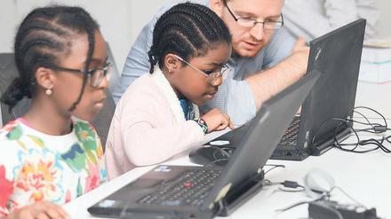 Wie funktionieren Programmiersprachen? Christoph Sterz erklärt der zehnjährigen Phoebe (l.) und der siebenjährigen Eve, wie man mit Programmiersprachen umgeht. 