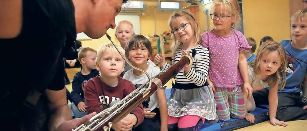 Vitaly Shlyakhov geht mit seinem Fagott dicht an die Kinder heran, damit sie die Schwingungen des Instrumentes spüren können.
