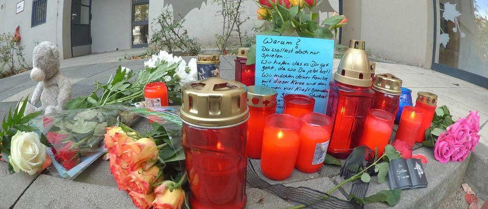 Vor einem Hochhaus im Märkischen Viertel in Berlin wurden Blumen und Kerzen abgelegt. Dort wurde ein acht Jahre alter Junge von einem Baumstumpf erschlagen.