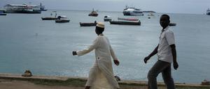 Das Foto zeigt Einheimische am Strand auf Sansibar, Tansania.
