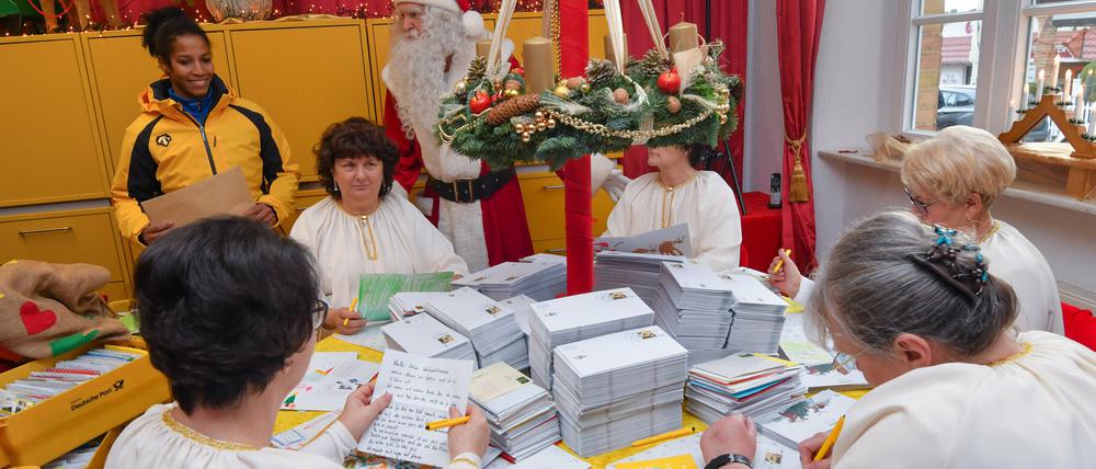 Mariama Jamanka (l), Olympiasiegerin 2018 im Zweierbob, und der Weihnachtsmann besuchen die Engel in der Weihnachtspostfiliale.
