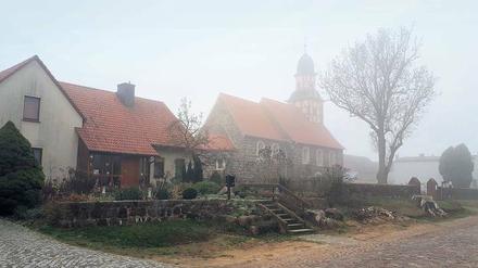 Die Dorfkirche in Raben bei Bad Belzig am Totensonntag, drinnen kondensiert die Atemluft der Gottesdienstbesucher zu Wölkchen.
