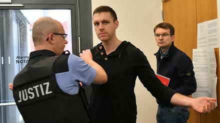 Ein Justizbeamter kontrolliert den ehemaligen NPD-Politiker Maik Schneider, bevor dieser den Gerichtssaal betreten darf. 
