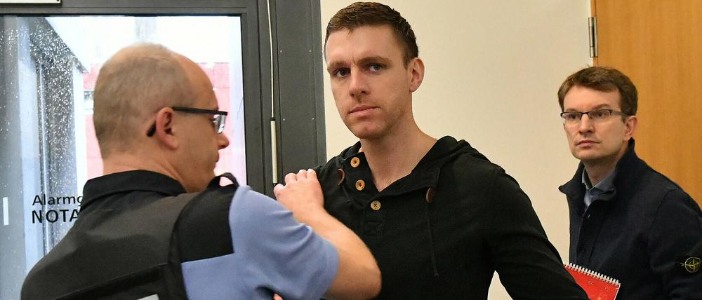 Ein Justizbeamter kontrolliert den ehemaligen NPD-Politiker Maik Schneider, bevor dieser den Gerichtssaal betreten darf. 