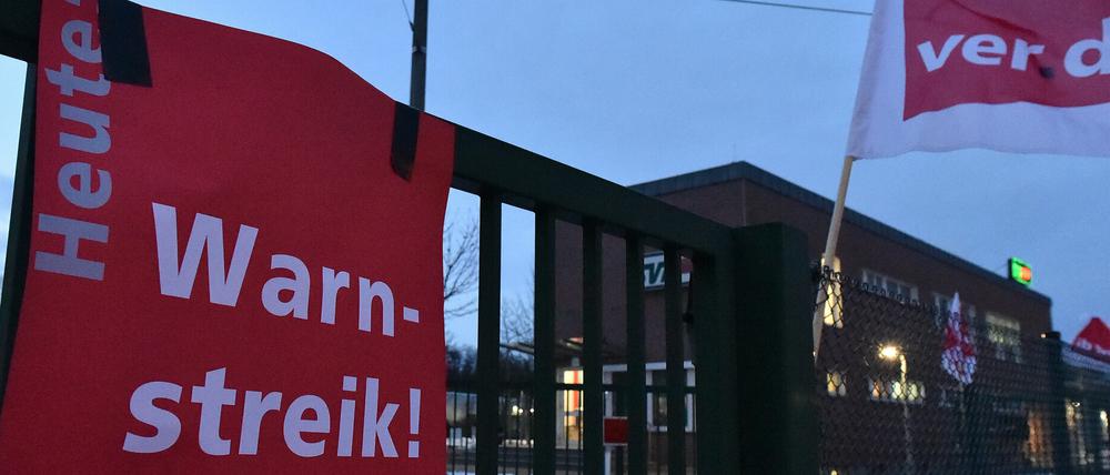 Ein Plakat mit der Aufschrift Warnstreik hängt an einem Tor am Depot der Straßen-Verkehrsgesellschaft.