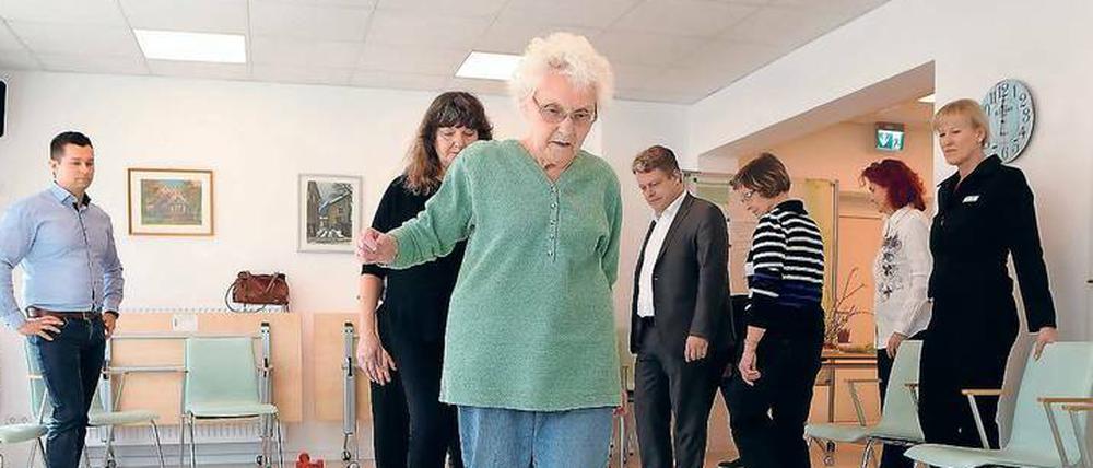 Mithilfe einer sogenannten Koordinationsleiter wird im Stahnsdorfer Seniorentreff Bewegungssicherheit eingeübt. Auch Bürgermeister Bernd Albers (BfB, 3.v.l.) probierte sich am Freitag darin aus.