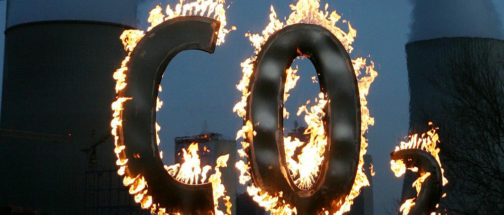 Mit einem brennenden CO 2-Zeichen demonstrierten Mitglieder der Umweltschutzorganisation Greenpeace vor dem Kohlekraftwerk Staudinger gegen den Schadstoffausstoß des Kraftwerkes.