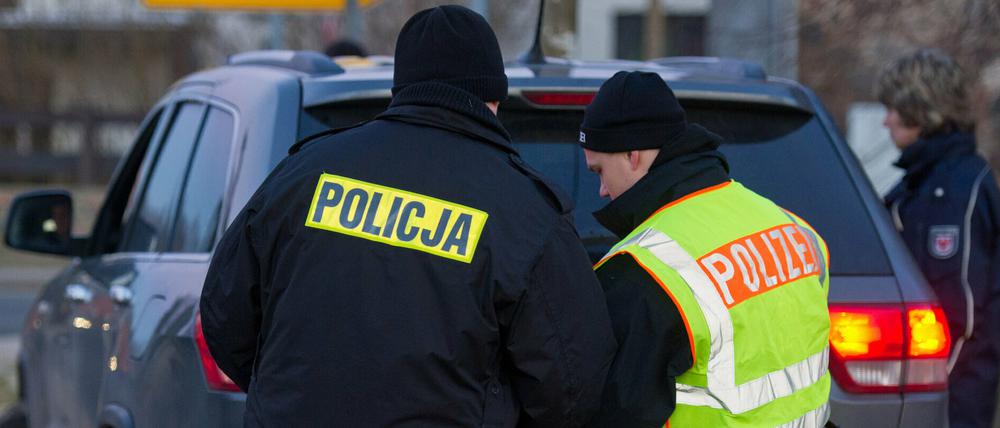 Polnische und deutsche Polizisten überprüfen in Biegen gemeinsam ein Auto.