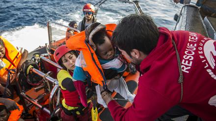 Ein Baby wird in ein Rettungsboot gebracht, nachdem eine spanische Nichtregierungsorganisation sie im zentralen Mittelmeer entdeckt und gerettet hat. 