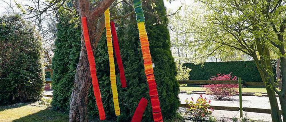 Aus Netzen gehäkelt. Bunte Säulen hängen am Eingang zur Ausstellung.
