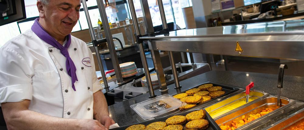 Ein Koch präsentiert vegane Bratlinge in einer Mensa der Freien Universität Berlin.