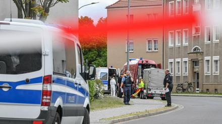 Polizeibeamte und Kriminaltechniker stehen vor dem mutmaßlichen Tatort in Forst in Brandenburg. 