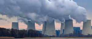 Wasserdampf steigt aus den Kühltürmen des Braunkohlekraftwerks Jänschwalde (Brandenburg) in den trüben Morgenhimmel. 