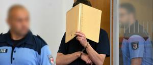 Im Gerichtssaal hält sich Kindermörder Silvio S. einen Aktenordner vors Gesicht.