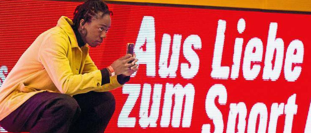 Jennifer Tuffour fotografiert für Handball-Drittligist VfL Potsdam. Auf der Werbebande bei einem Spiel steht ein Motto, das zu ihr passt.