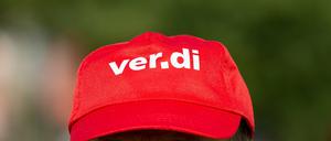 Ein Bankangestellter trägt beim Warnstreik eine Mütze mit dem Verdi Logo. 