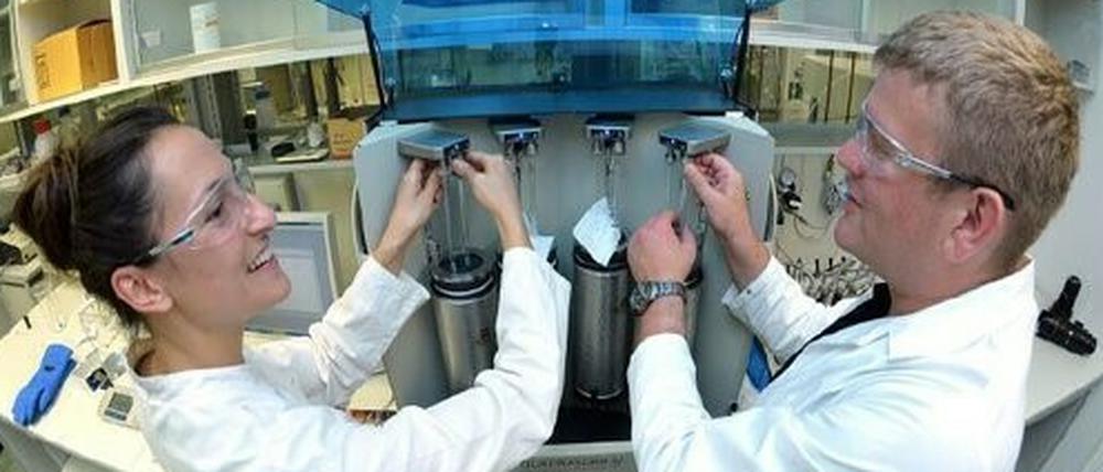 Milena Perovic und Martin Oschatz bereiten eine Messung vor, mit der sie die Oberfläche von Kohlenstoffmaterialien bestimmen. Das Gerät ermittelt, wie viel Gas die vier Proben aufnehmen können, die sich dabei in Kühlgefäßen befinden.