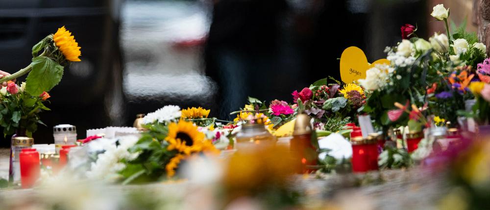 Eine Frau legt an der Mauer vor der Synagoge eine Sonnenblume nieder.