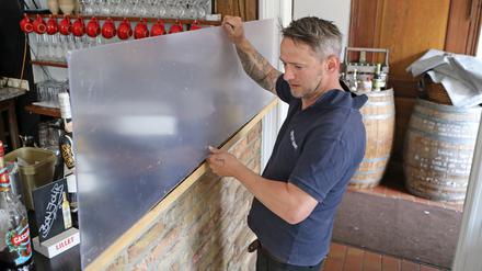 Im Restaurant Potsdamer "La Madeleine" schirmt eine Spuckschutzscheibe am Tresen Mitarbeiter ab.