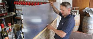 Im Restaurant Potsdamer "La Madeleine" schirmt eine Spuckschutzscheibe am Tresen Mitarbeiter ab.