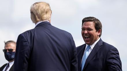 U.S. President Donald Trump is greeted by Florida Governor Ron Desantis as he arrives at Southwest Florida International Airport ahead of a campaign stop in Fort Myers, Florida, U.S., October 16, 2020. REUTERS/Carlos Barria