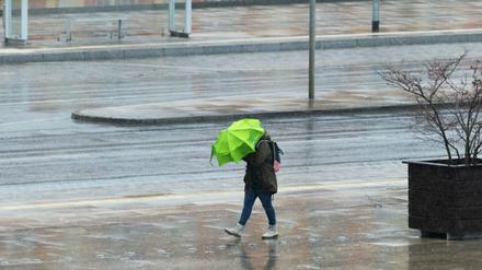 Ungemütlich. Mit einem Schirm versuchte eine Frau in Potsdam, sich vor dem Wind und dem Regen zu schützen.