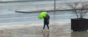 Ungemütlich. Mit einem Schirm versuchte eine Frau in Potsdam, sich vor dem Wind und dem Regen zu schützen.
