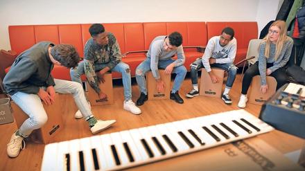 Trompeter Konstantin Döben und die Potsdamer Fahland-Azubis Zame Ahmadi, Saidou Sidibé, Khalid Mohamed Yusuf und Lee Ann Brückner (v.l.) beim Trommeln auf Cajons.
