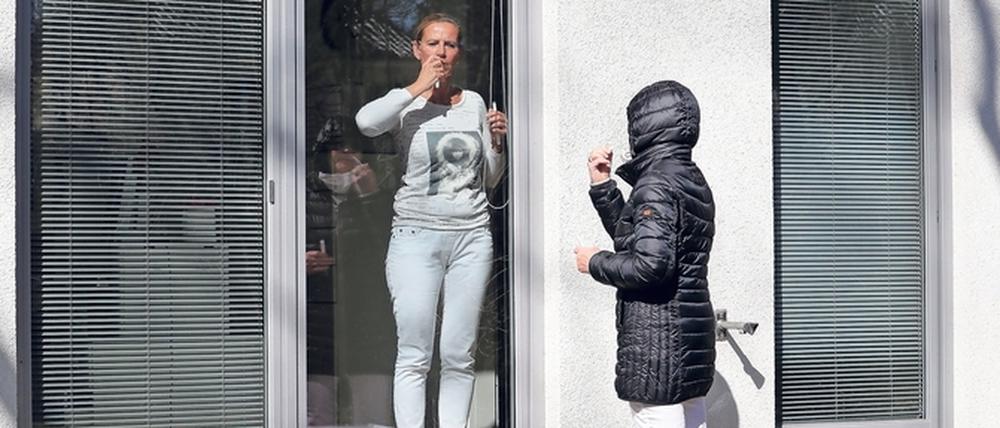 Weil Ärztin Margit Inacker Schutzausrüstung fehlt, müssen sich ihre Patienten selbst auf das Coronavirus testen. Dazu gibt sie Anweisungen durch das geschlossene Fenster und via laut gestelltem Handy.