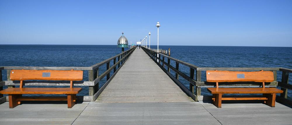 05.04.2020, Mecklenburg-Vorpommern, Zinnowitz: Zwei Spaziergänger gehen auf der Seebrücke im Ostseebad Zinnowitz auf der Insel Usedom. Wegen der scharfen Einschränkungen im öffentlichen Leben wird der traditionelle Saisonauftakt an der Ostsee zu Ostern in diesem Jahr ausfallen. Foto: Stefan Sauer/dpa +++ dpa-Bildfunk +++