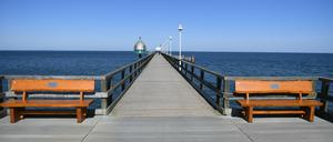 05.04.2020, Mecklenburg-Vorpommern, Zinnowitz: Zwei Spaziergänger gehen auf der Seebrücke im Ostseebad Zinnowitz auf der Insel Usedom. Wegen der scharfen Einschränkungen im öffentlichen Leben wird der traditionelle Saisonauftakt an der Ostsee zu Ostern in diesem Jahr ausfallen. Foto: Stefan Sauer/dpa +++ dpa-Bildfunk +++