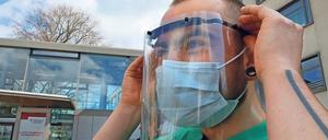 Durchblick. Mitglieder des „Wissenschaftsladens“ Potsdam drucken Einzelteile für Schutzvisiere und übergaben 300 Stück davon an das St. Josefs-Krankenhaus in Potsdam. Pfleger Bela demonstriert die Handhabung der Visiere. Fotos: Andres Klaer