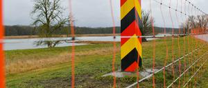 Schutzzaun gegen die Afrikanische Schweinepest an einem deutschen Grenzpfeiler auf dem Deich in Frankfurt (Oder) am deutsch-polnischen Grenzfluss Oder.