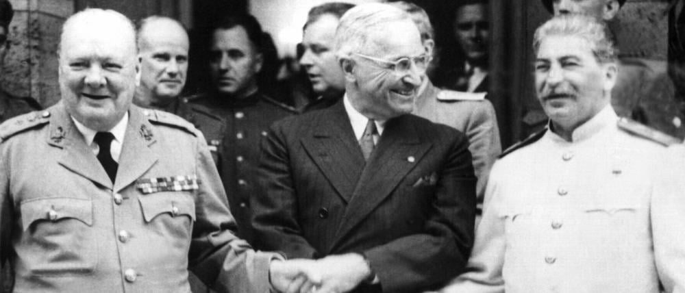 Der britische Premierminister Winston Churchill, der amerikanische Präsident Harry S. Truman und der sowjetische Diktator Josef Stalin (v. l. n. r.) reichen sich während der Potsdamer Konferenz vor der Villa Urbig die Hände.