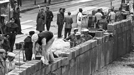 Baubeginn der Mauer: Unter der Aufsicht von bewaffneten Volkspolizisten errichtete 1961 eine Ostberliner Maurerkolonne an der sowjetisch-amerikanischen Sektorengenze am Potsdamer Platz in Berlin eine Mauer. 