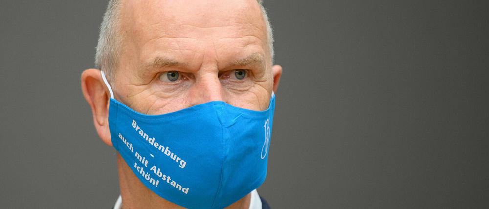 Dietmar Woidke (SPD), Ministerpräsident von Brandenburg, mit einem blauen Mund-Nasenschutz mit der Aufschrift «Brandenburg - auch mit Abstand schön».