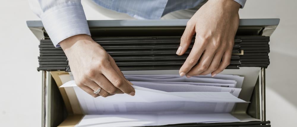 Eine Frau sortiert Akten im Büro.