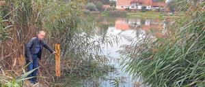 Stand der Dinge. Karsten Stornowski, Vize-Landrat und Umweltdezernet im Landkreis Uckermark, zeigt, welche Höhe der Dorfteich in Schmiedeberg früher hatte. Davon ist nicht mehr viel übrig.