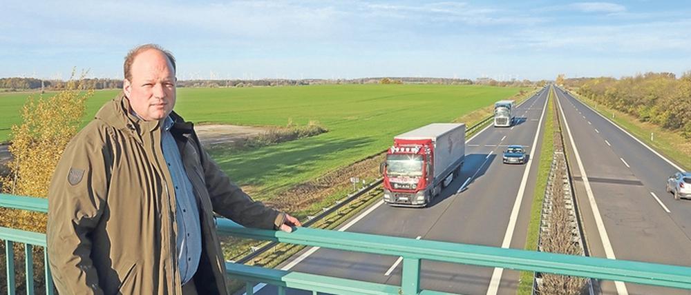 Stephan Otten, Betriebsleiter Agro Uetz-Bornim GmbH, auf einer Brücke über die A10. Die Hälfte des Areals links soll Raststätte werden.