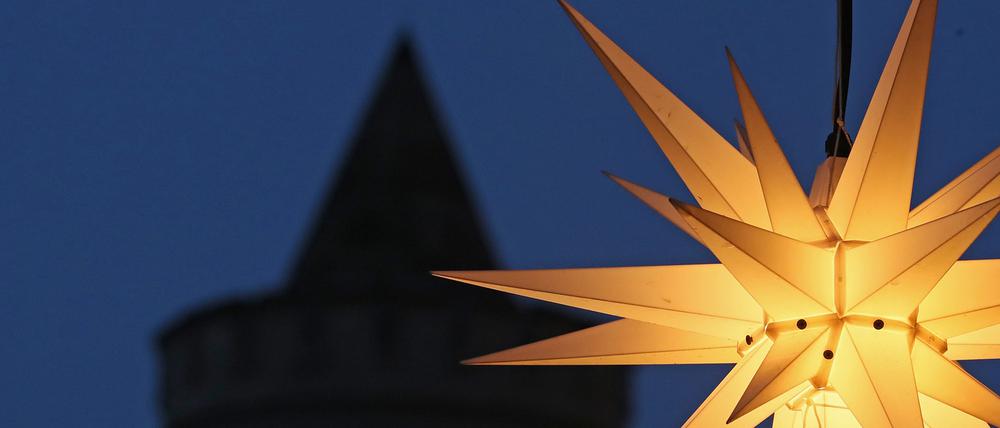 Ein Stern leuchtet vor einem Turm des Nauener Tors in Potsdam.