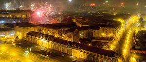 Blick vom Hotel Mercure auf die beleuchtete Breite Straße und das Filmmuseum während in der Silvesternacht Feuerwerk in den Nachthimmel aufsteigt. 
