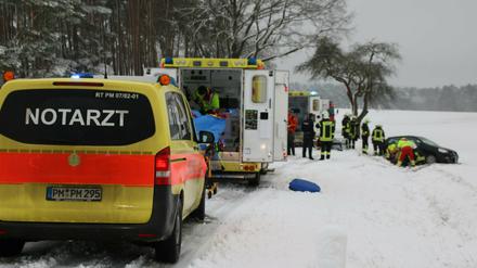 Einsatzkräfte der Polizei und Feuerwehr versorgen nach einem Unfall auf der L84 die verletzten Fahrzeuginsassen eines Autos.