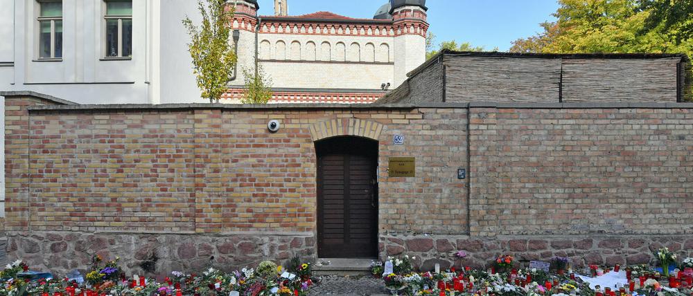Blumen und Kerzen stehen neben der Tür zur Synagoge, vier Tage nach dem rechtsextremistischen Anschlag auf die Gemeinde. Foto: Hendrik Schmidt/dpa-Zentralbild/dpa +++ dpa-Bildfunk +++