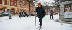 Zwei Potsdamerinnen fahren auf Langlauf-Ski über den schneebedeckten Fußweg am Bassinplatz.