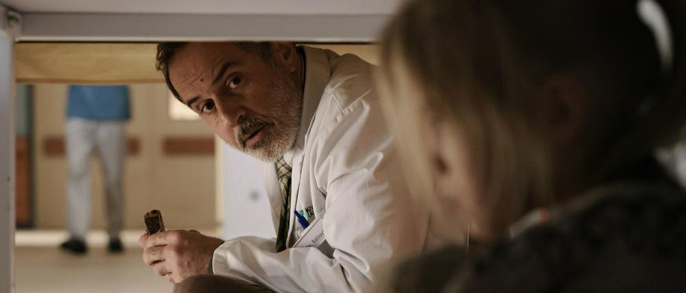 Doktor Ballouz (Merab Ninidze) setzt sich zu Flori (Mavie Meschkowski) unter den Tisch - eine Szene der aus der ZDF-Reihe.