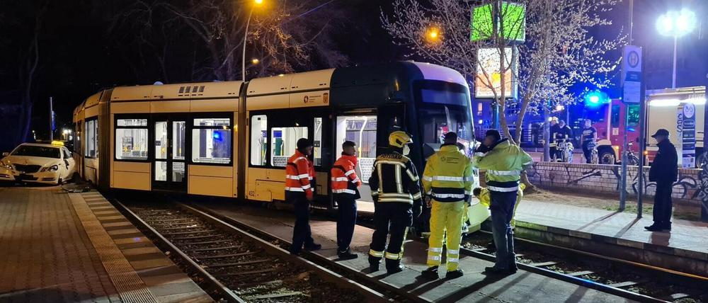 Einsatzkräfte stehen neben der entgleisten Straßenbahn.