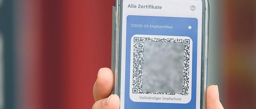 Der Impfnachweis, der als QR-Code in einer Smartphone-App gespeichert werden kann, soll etwa das Reisen und Restaurantbesuche erleichtern.