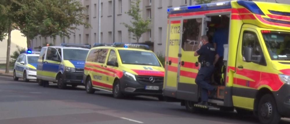 Vor einem Haus in Rathenow stehen Polizeiautos sowie Rettungswagen und das Auto eines Notarztes.